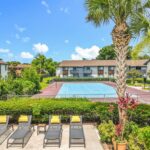 Outdoor tennis court next to apartment buildings and patio lounge space