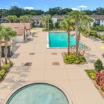 Exterior shot of pool with patio space and hot tub